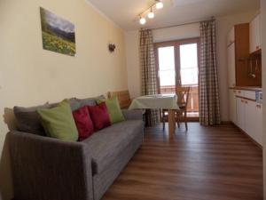a living room with a couch and a table at Ferienhof Hefele Ferienwohnung Weißensee mit KönigsCard in Hopferau