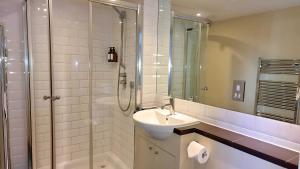 uma casa de banho com um lavatório e um chuveiro em It's The One One One in Notting Hill! -5- em Londres