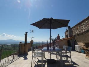 einen Tisch und Stühle mit Sonnenschirm auf einer Terrasse in der Unterkunft Scappo in Umbria, La Terrazza in Lugnano in Teverina