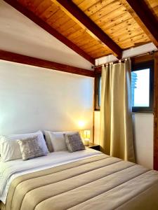 una camera da letto con un grande letto e una finestra di "THE ATTIC" - Appartamento Esclusivo con Parcheggio Gratuito a Marano di Napoli