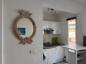 cocina blanca con espejo en la pared en Grand studio de 30 m2 Promenade des Anglais en Niza