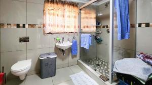 y baño con ducha, aseo y lavamanos. en Sea Park Holi-Stay - 2on1stAve, en Port Shepstone