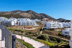 a view of a city with white buildings and mountains at Mara's Apartments Higueron West - Like A House - 246 Square Meters of Private Terrace & Garden - Morning and Evening Sun in Fuengirola