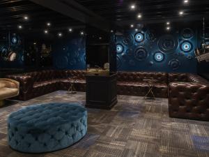 una habitación con sofás de cuero y una pared azul en Hotel Relax II, en Taipéi