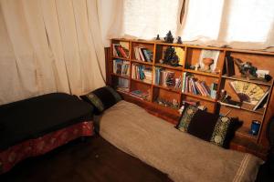 uma sala de estar com um sofá e uma estante de livros em Panorama Inn Mustang em Muktināth