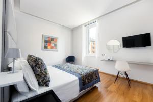 a white bedroom with a bed and a tv at Mascherino Suites in Rome