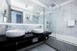 a bathroom with two sinks on a black counter at Mascherino Suites in Rome