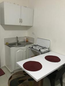 a white kitchen with a sink and a stove at 2SB Hospedagem in Praia
