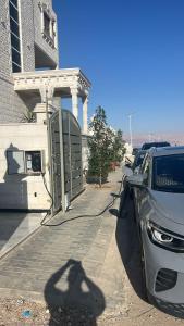 um parque de estacionamento com carros estacionados em frente a um edifício em ENG-Murjan Apartment em Aqaba