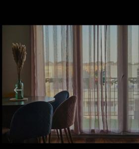 uma mesa de jantar e cadeiras em frente a uma janela em Grand et bel appartement de 2 chambres chez Cyn em Salon-de-Provence