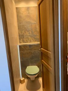 baño con aseo y asiento verde en Maison lumineuse aux portes de Montpellier, en Vailhauquès