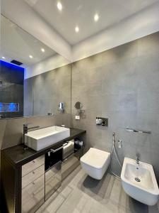 La salle de bains est pourvue de toilettes blanches et d'un lavabo. dans l'établissement CeO LUXURY SUITE DI CAGLIARI, à Cagliari