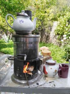 a stove with a tea pot and a fire at Misafir Evi in Kayakoy