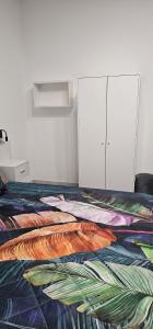uma cama com um edredão colorido num quarto em Vittoria's rooms em Roma