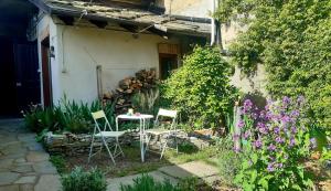 a table and chairs sitting outside of a house at La Marmotta in Luserna San Giovanni