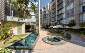 an external view of a building with a swimming pool at Bonito Departamento en Sonata in Lomas de Angelopolis