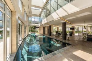 an indoor pool in a building with glass walls at Bonito Departamento en Sonata in Lomas de Angelopolis