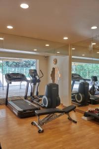 a gym with treadmills and exercise bikes and a mirror at Hotel Residency Andheri in Mumbai