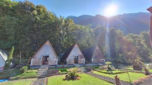 a row of cottages with the mountains in the background at Popitan Garden Campground & Glamping Bedugul in Bedugul