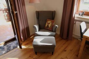 a chair and an ottoman in a living room at Isarkindl in Krün