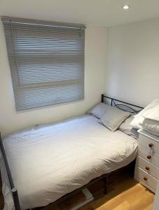 a small bedroom with a bed and a window at Sheepy village Leysdown in Leysdown-on-Sea