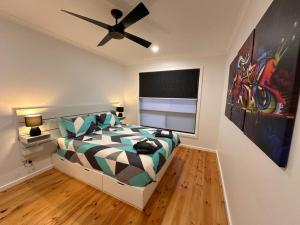 een slaapkamer met een bed en een plafondventilator bij The Hilltop, spacious family retreat with views! in Port Lincoln