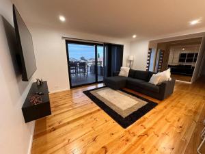 een woonkamer met een bank en een televisie bij The Hilltop, spacious family retreat with views! in Port Lincoln
