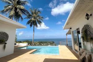 a villa with a swimming pool and a view of the ocean at Blue Bay Villa in Haad Yao
