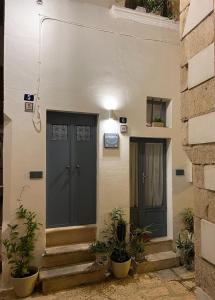 een huis met een zwarte deur en wat planten bij B&B A Casa di Marilù in Martina Franca
