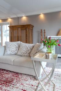 - un salon avec un canapé blanc et une table dans l'établissement Luxus Sönshörn 16, à Munkmarsch