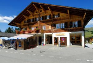 un gran edificio de madera con una tienda frente a él en Chambre double Doppelzimmer Camping Jaunpass, en Boltigen