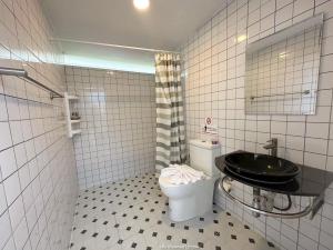 Ban Tha Chang的住宿－Chavallee Campground，浴室设有黑色的卫生间和水槽。
