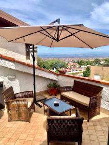 patio con tavolo, sedie e ombrellone di "THE ATTIC" - Appartamento Esclusivo con Parcheggio Gratuito a Marano di Napoli