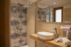 a bathroom with a sink and a shower with a mirror at Albergo La Romanella in Spinone Al Lago