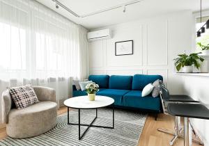 sala de estar con sofá azul y mesa en Stylowy apartament przy metrze, en Varsovia