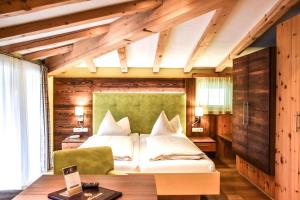 a bedroom with a bed with a green headboard at Hotel Lärchenhof in Lermoos