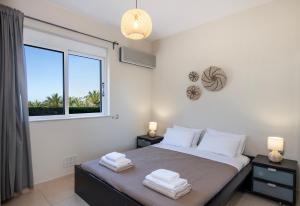 1 dormitorio con 1 cama con toallas en Gabriel apartment with a shared pool close to the beach, en Chorafakia