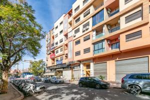 un edificio alto con macchine parcheggiate di fronte di Cozy 2-bedroom apartment in Gueliz, Marrakech a Marrakech