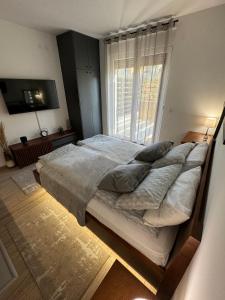 a large bed in a bedroom with a window at Apartmani Viver Vrnjačka Banja in Vrnjci