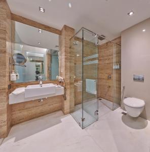 a bathroom with a shower and a toilet and a sink at Hotel Residency Andheri in Mumbai