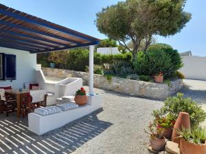 een terras met een tafel en stoelen onder een pergola bij Ferienhaus mit atemberaubendem Meerblick, privatem Pool und Whirlpool in Aliko Beach