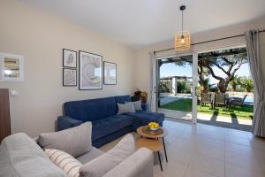 a living room with a blue couch and a table at Gabriel apartment with a shared pool close to the beach in Chorafakia