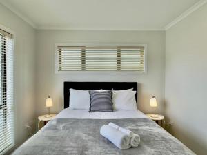 a bedroom with a large bed with two lamps at Glendowie Brand-new comfortable 3 & 4-bedroom Houses in Auckland