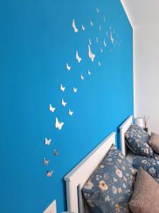 a blue room with a bed with butterflies on the wall at La Collina del Poeta in Arquà Petrarca +53 photos