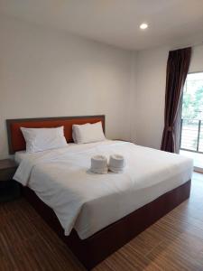 a bedroom with a large bed with two towels on it at Sisina Resort in Prachuap Khiri Khan