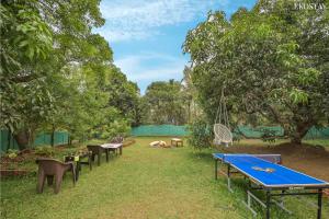 - un groupe de tables de ping-pong et de chaises dans un parc dans l'établissement EKOSTAY - Forestwood Villa, à Alibaug