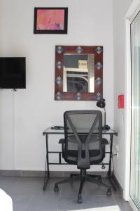 a desk with a chair in a room with a mirror at Studio 20m² au calme à Idron (5min de Pau) in Idron