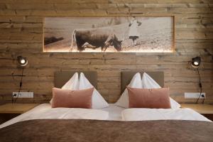 a bedroom with a bed with a cow on the wall at Dolomite Apartments - by Familiaris in San Candido