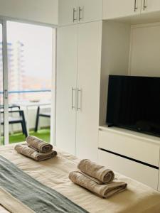 - une chambre avec 2 serviettes sur un lit et une télévision dans l'établissement KAI Apartment - Swimming Pool - AC, à Playa Paraiso