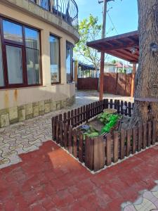 a wooden fence next to a tree next to a building at Casa Ancuta in Eforie Sud